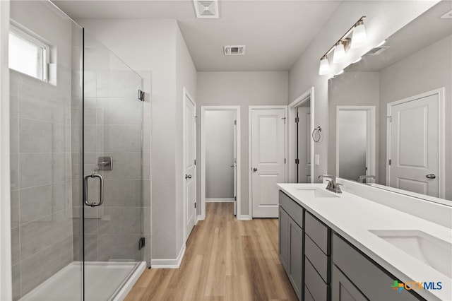 bathroom featuring vanity, hardwood / wood-style flooring, and a shower with shower door