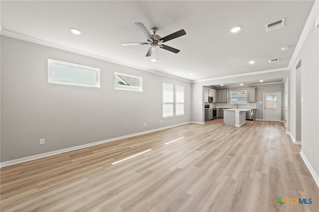 unfurnished living room with ornamental molding, light wood-type flooring, ceiling fan, and sink