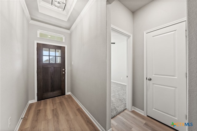 entrance foyer with ornamental molding and light hardwood / wood-style flooring