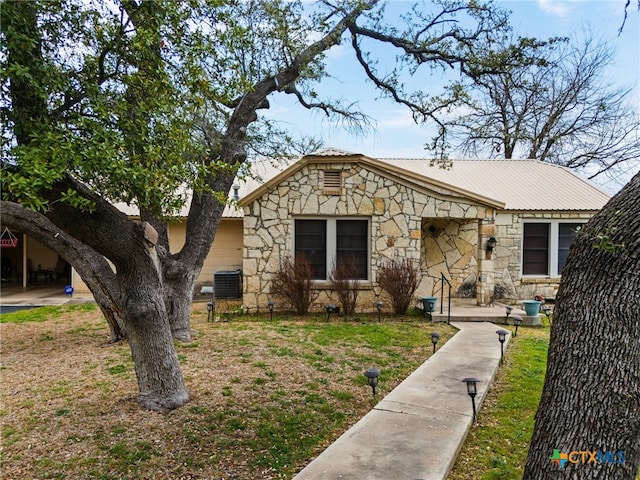 bungalow-style home featuring central AC unit and a front yard