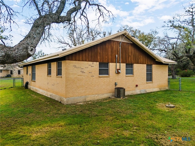 view of side of home featuring central air condition unit and a yard