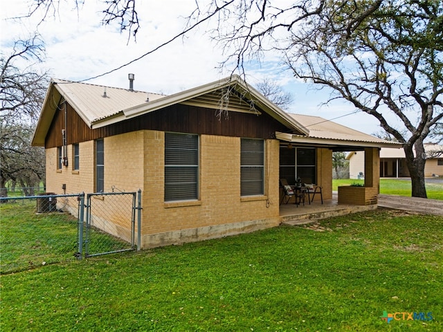 back of property with a lawn and a patio