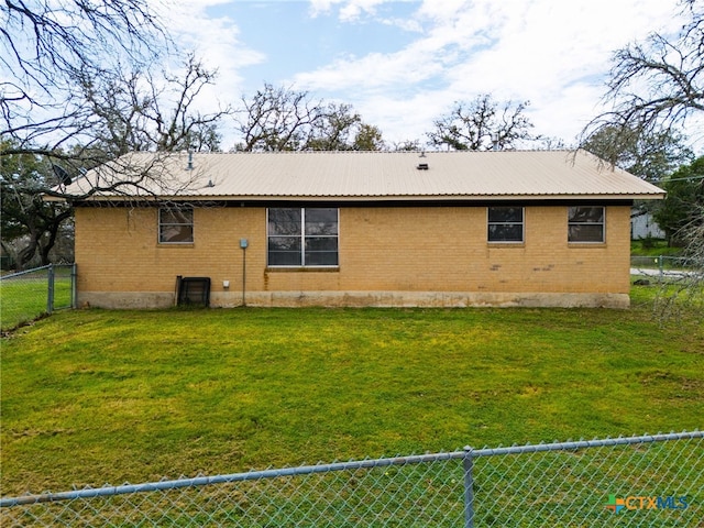 rear view of house featuring a lawn