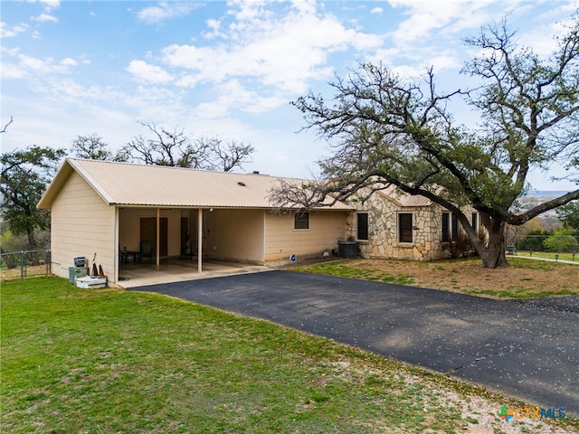 view of front facade featuring a front lawn, cooling unit, and a carport