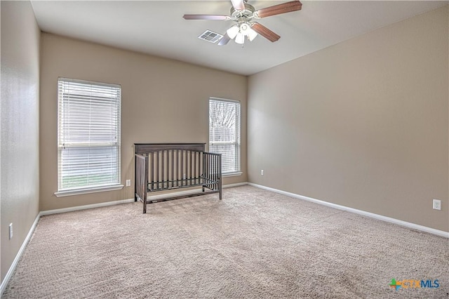 bedroom featuring carpet floors, multiple windows, visible vents, and baseboards