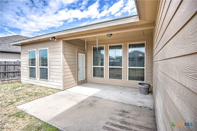 property entrance featuring a patio and fence