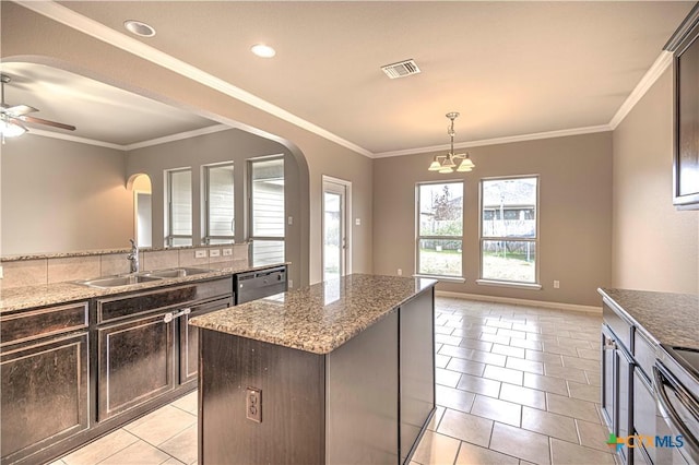 kitchen featuring light stone countertops, sink, light tile patterned floors, dishwasher, and a kitchen island