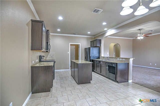 kitchen with a ceiling fan, arched walkways, a kitchen island, and black appliances