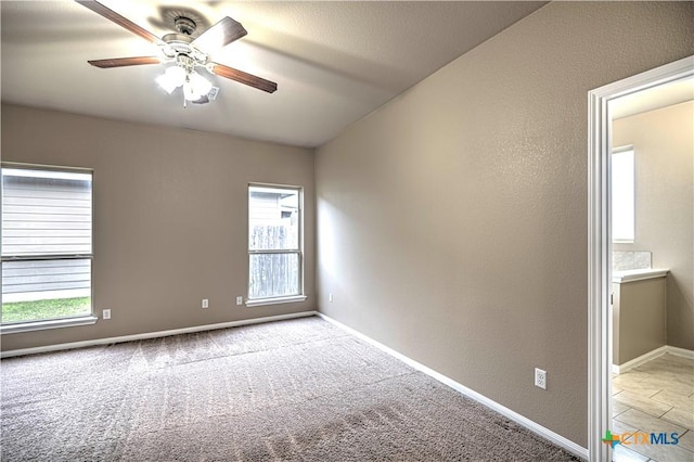 carpeted spare room featuring ceiling fan