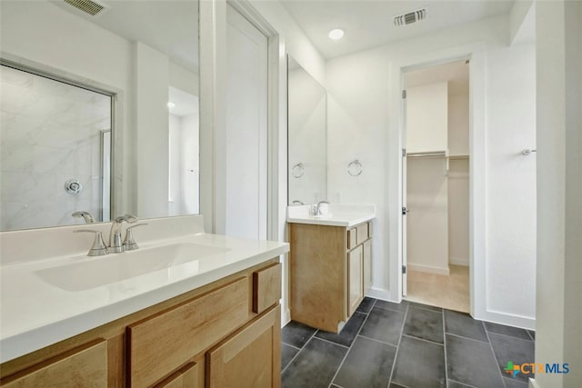 bathroom with tile patterned floors, vanity, and a shower with door