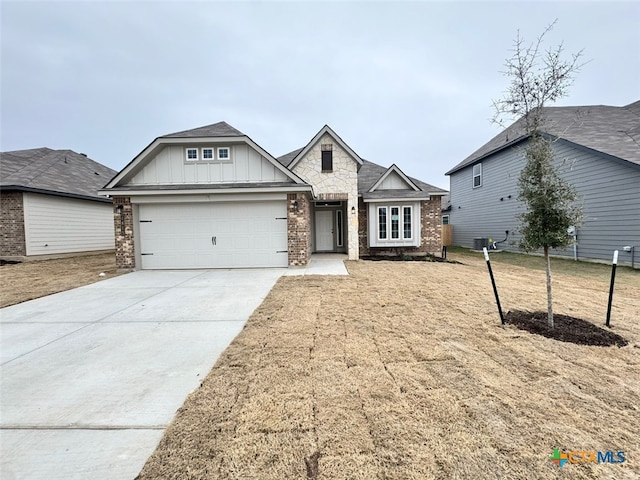 view of front of home with a garage, central AC, and a front yard