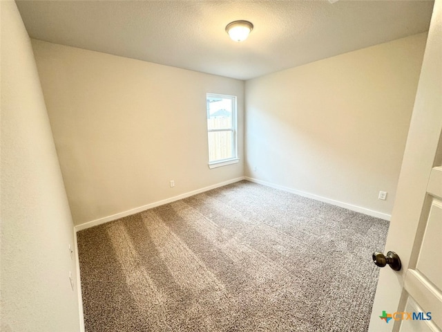 spare room with a textured ceiling and carpet