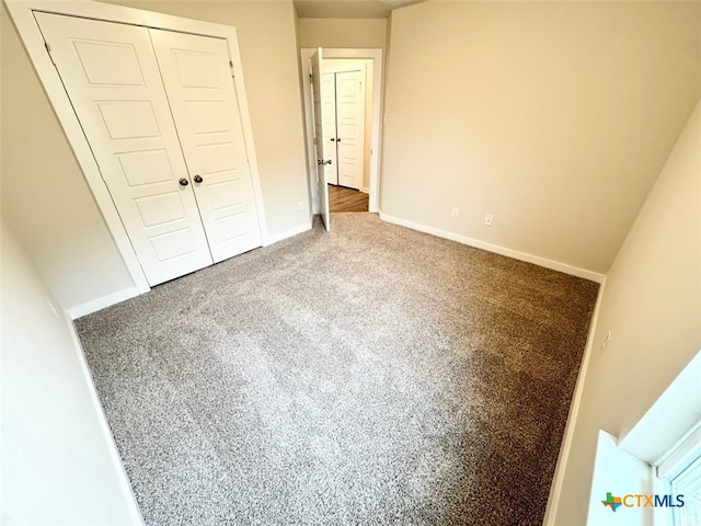 unfurnished bedroom featuring carpet floors and a closet