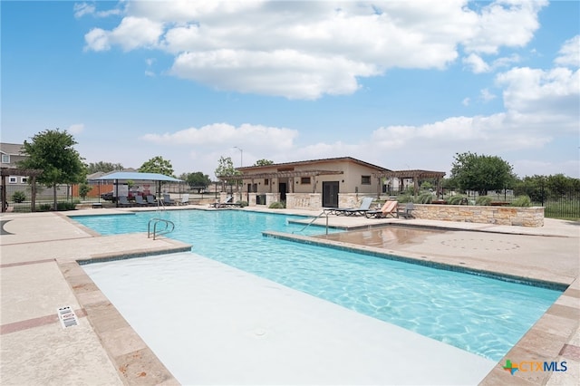 community pool with fence and a patio area