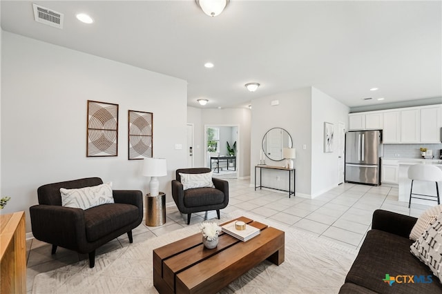 living room with light tile patterned flooring, recessed lighting, and baseboards