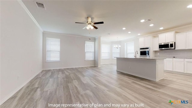 5105 Othello Dr, Belton, TX 76513 - kitchen with stainless steel appliances, ornamental molding, a chandelier, open floor plan, and light wood-style flooring