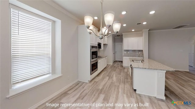5105 Othello Dr, Belton, TX 76513 - kitchen with ornamental molding, recessed lighting, light wood finished floors, tasteful backsplash, and white cabinets