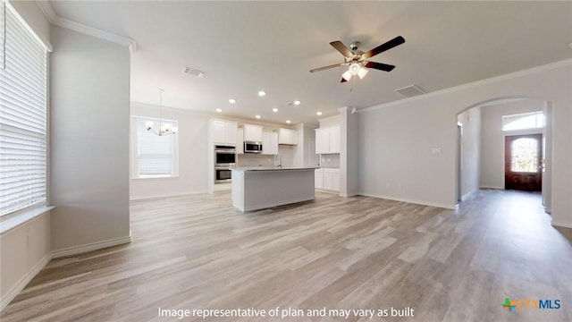 5105 Othello Dr, Belton, TX 76513 - kitchen featuring appliances with stainless steel finishes, open floor plan, crown molding, arched walkways, and white cabinetry