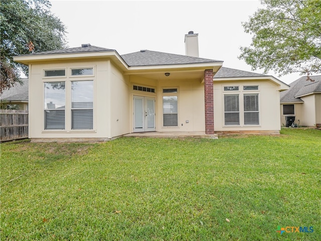 back of property featuring a yard