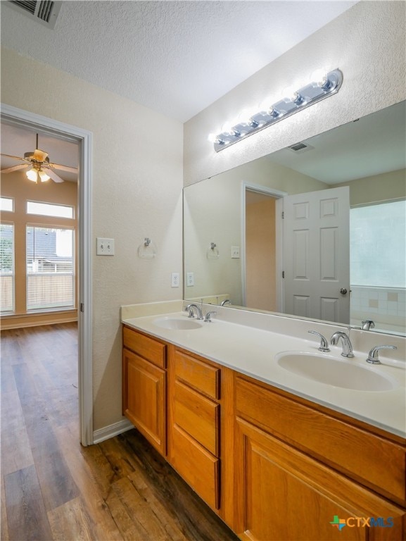 bathroom with vanity, a textured ceiling, hardwood / wood-style flooring, and ceiling fan