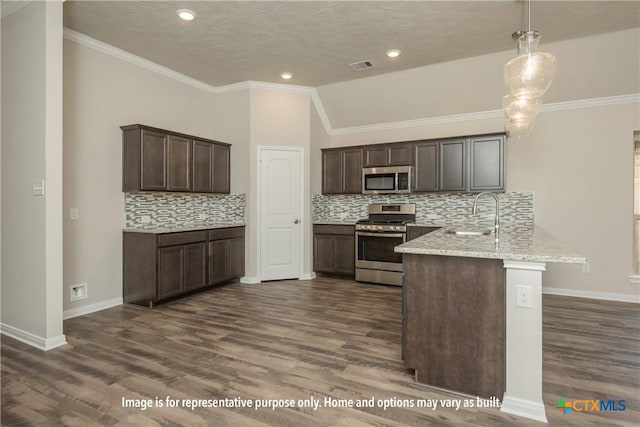 kitchen featuring dark hardwood / wood-style flooring, kitchen peninsula, stainless steel appliances, and hanging light fixtures