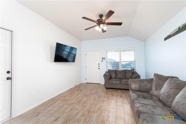 living area with light wood-type flooring, vaulted ceiling, ceiling fan, and baseboards