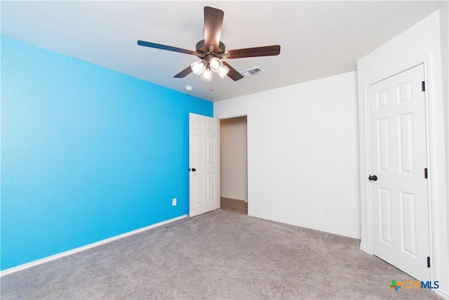 unfurnished bedroom featuring light carpet, ceiling fan, visible vents, and baseboards