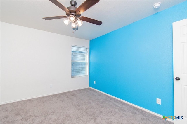 spare room featuring a ceiling fan, light colored carpet, and baseboards