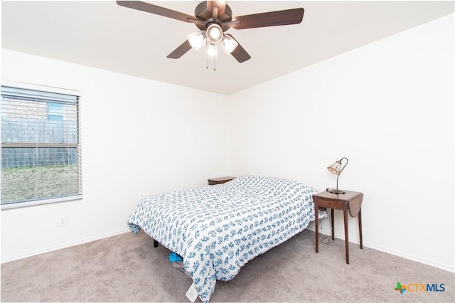 bedroom featuring a ceiling fan, light colored carpet, and baseboards