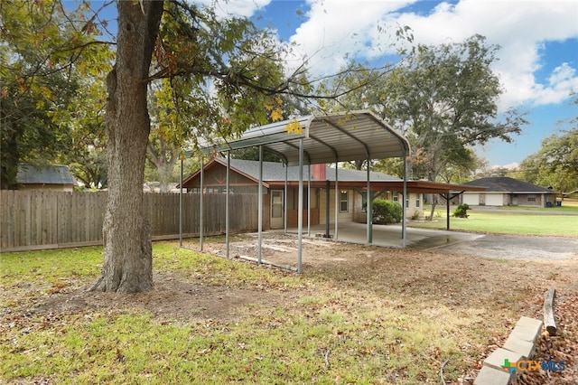 view of yard featuring a patio, a detached carport, and fence