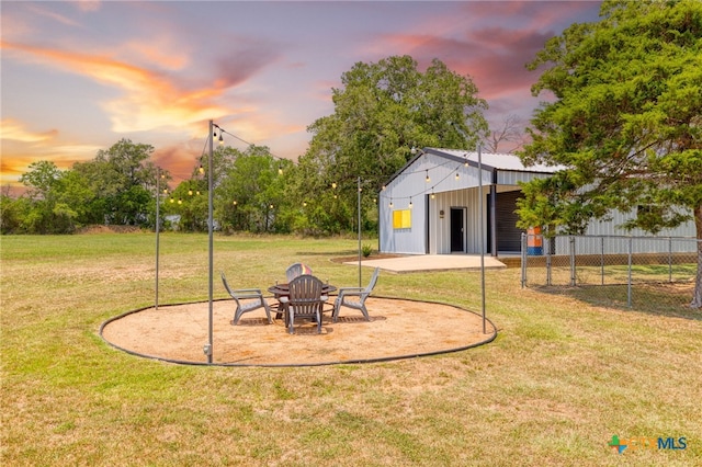 1600 Cattlemens Row, Lockhart, TX 78644 - yard at dusk featuring an outbuilding and a pole building
