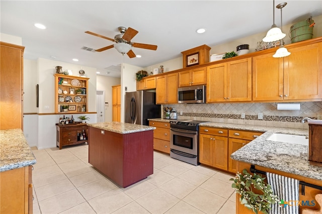1600 Cattlemens Row, Lockhart, TX 78644 - kitchen with appliances with stainless steel finishes, a sink, a ceiling fan, tasteful backsplash, and light stone counters