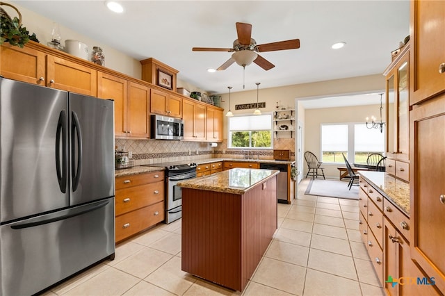 1600 Cattlemens Row, Lockhart, TX 78644 - kitchen featuring appliances with stainless steel finishes, brown cabinetry, backsplash, light stone counters, and recessed lighting