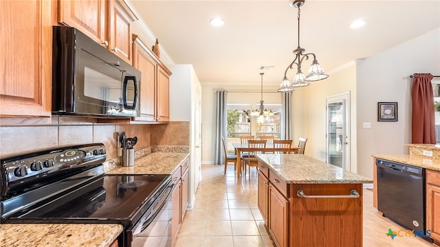 kitchen with pendant lighting, a center island, black appliances, ornamental molding, and a chandelier