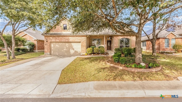 view of front of home featuring brick siding, an attached garage, concrete driveway, and a front yard