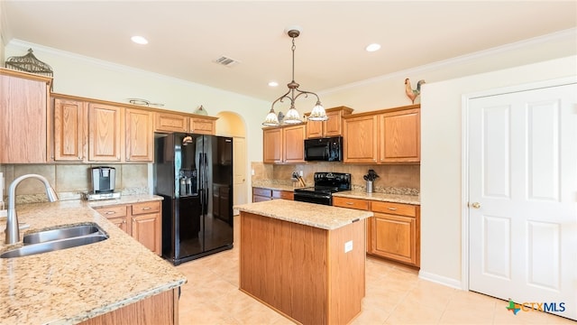 kitchen featuring tasteful backsplash, sink, black appliances, a kitchen island, and hanging light fixtures