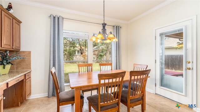 dining area with light tile patterned floors, ornamental molding, and an inviting chandelier