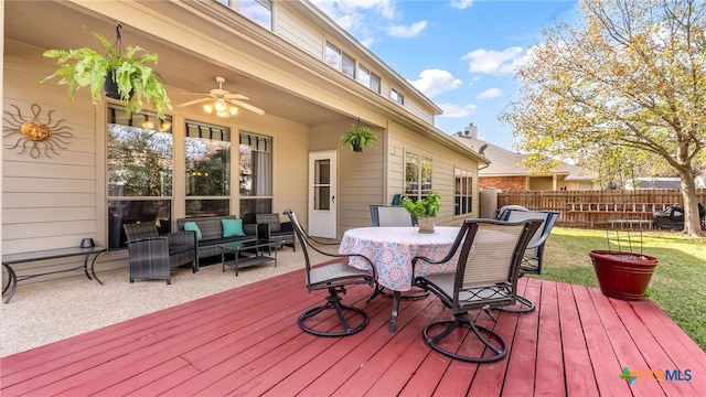 deck featuring outdoor lounge area, ceiling fan, and a yard