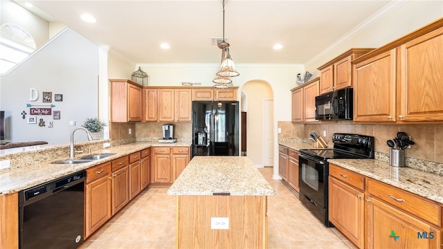 kitchen with a center island, black appliances, sink, decorative light fixtures, and light stone counters