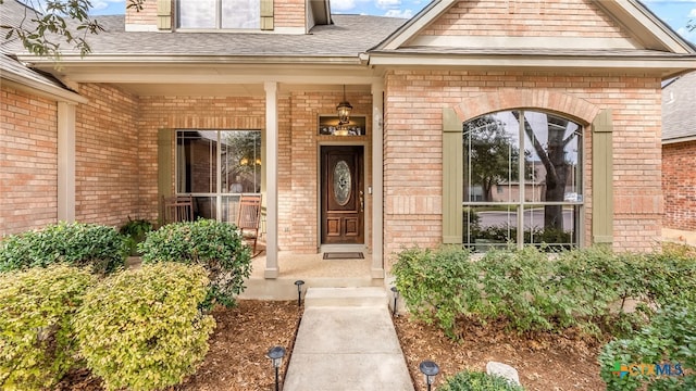 view of exterior entry featuring covered porch