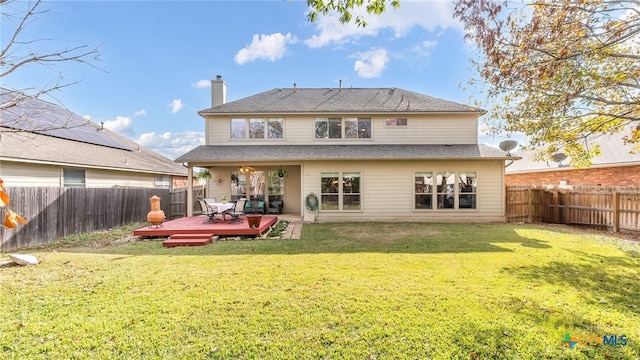 back of house with a lawn and a wooden deck