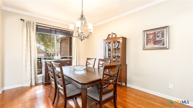 dining area featuring crown molding, wood-type flooring, and a notable chandelier