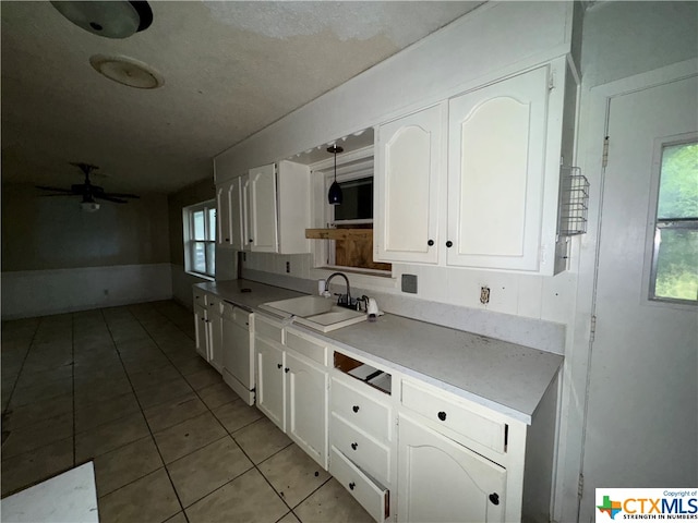 kitchen with white dishwasher, plenty of natural light, white cabinetry, and sink