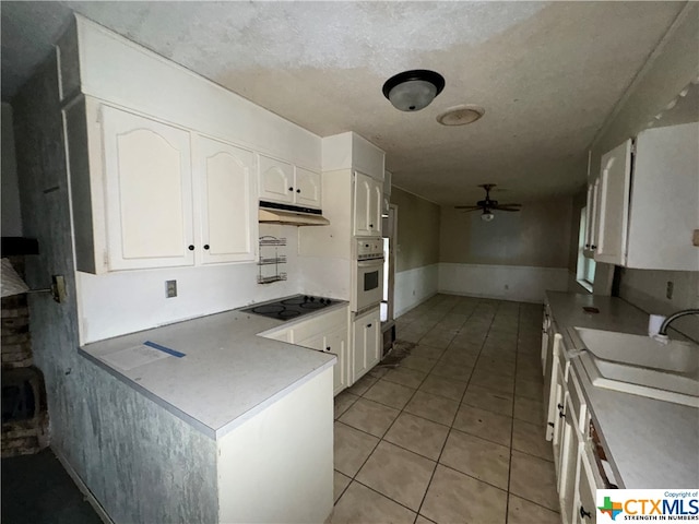 kitchen with ceiling fan, sink, oven, black electric cooktop, and white cabinets