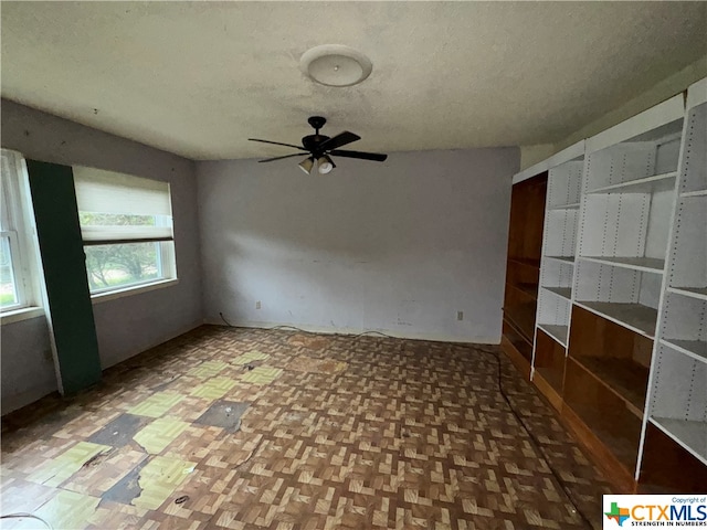 spare room featuring ceiling fan and parquet flooring