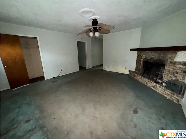 unfurnished living room with ceiling fan and a brick fireplace