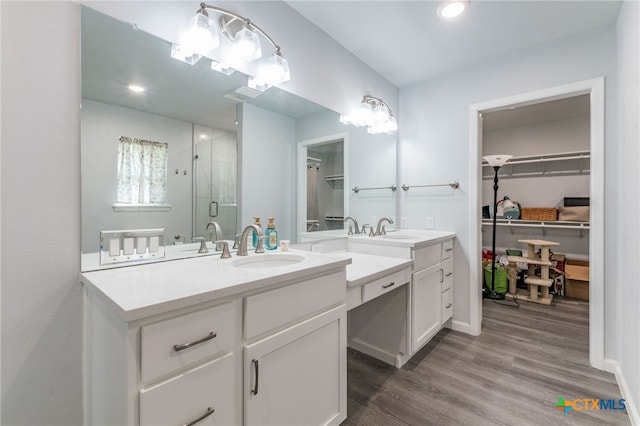 501 College Ave, Florence, TX 76527 - bathroom featuring a spacious closet, vanity, a shower stall, wood finished floors, and recessed lighting