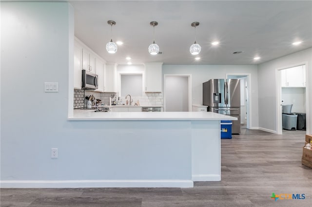 501 College Ave, Florence, TX 76527 - kitchen featuring stainless steel appliances, light countertops, decorative backsplash, a peninsula, and white cabinets