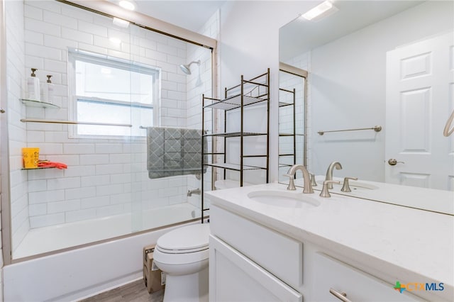 501 College Ave, Florence, TX 76527 - bathroom featuring vanity, enclosed tub / shower combo, and wood finished floors