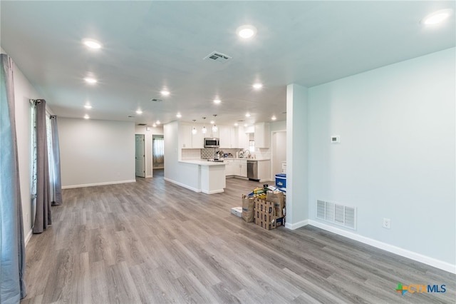 501 College Ave, Florence, TX 76527 - unfurnished living room with recessed lighting and light wood-type flooring